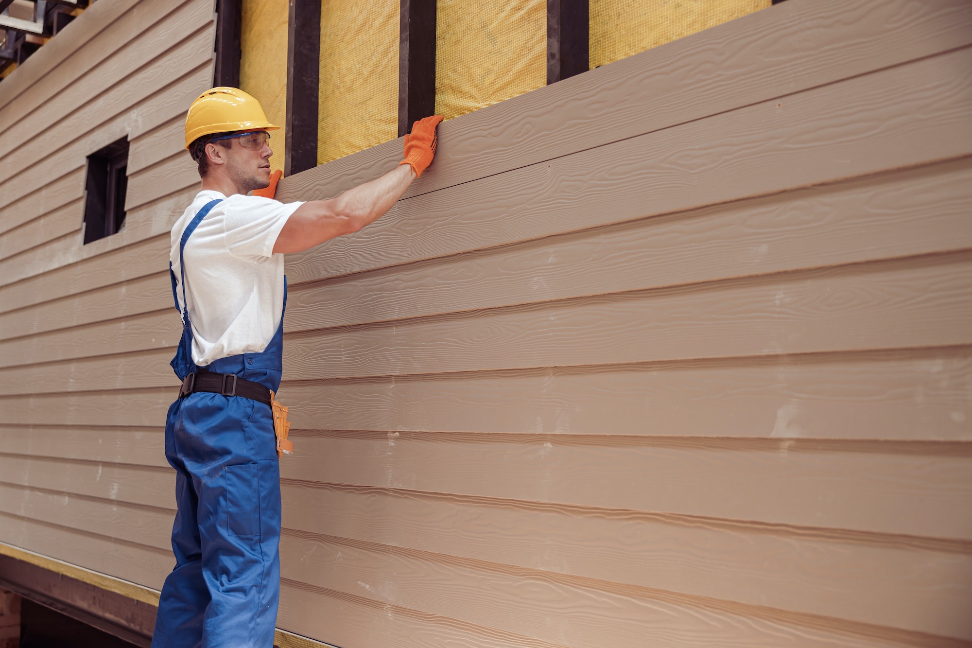 Male worker building house at construction site